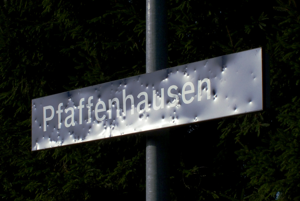   Pfaffenhausen kurz nach dem Angriff  (der Schüler) So könnte man dieses Bild betiteln. So sieht ein Bahnhofsschild aus wenn es mit Schottersteinen beschossen wird. Wie immer ist es niemand gewesen... (22.08.2012)